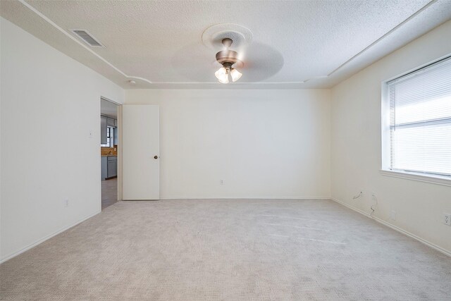 carpeted spare room featuring a textured ceiling and ceiling fan