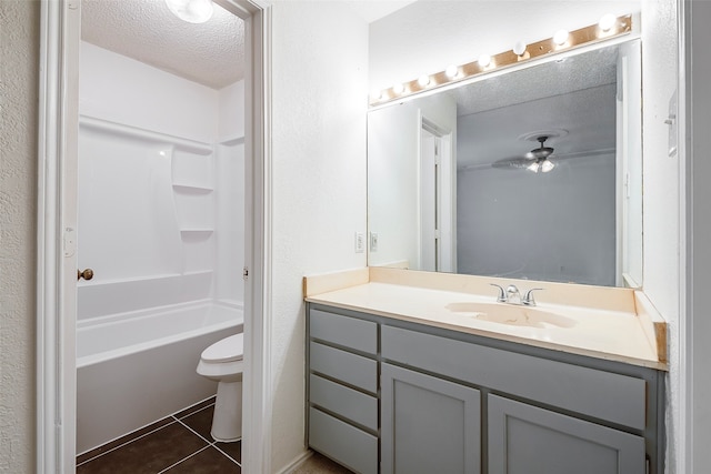 full bathroom featuring a textured ceiling, vanity, tile patterned flooring, toilet, and  shower combination