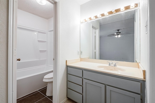 bathroom featuring toilet, washtub / shower combination, vanity, a textured ceiling, and tile patterned floors