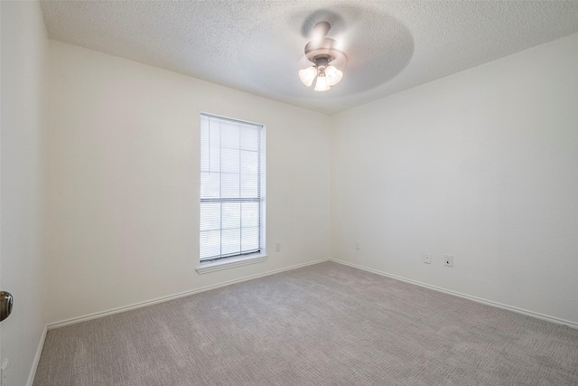 carpeted empty room featuring a textured ceiling, baseboards, and a ceiling fan