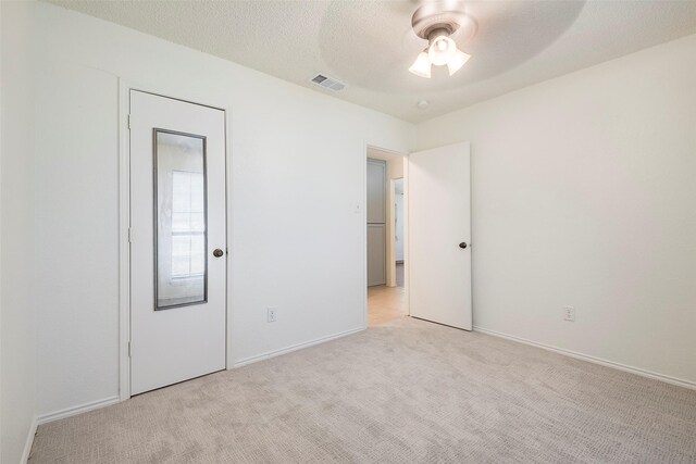 carpeted spare room with ceiling fan and a textured ceiling