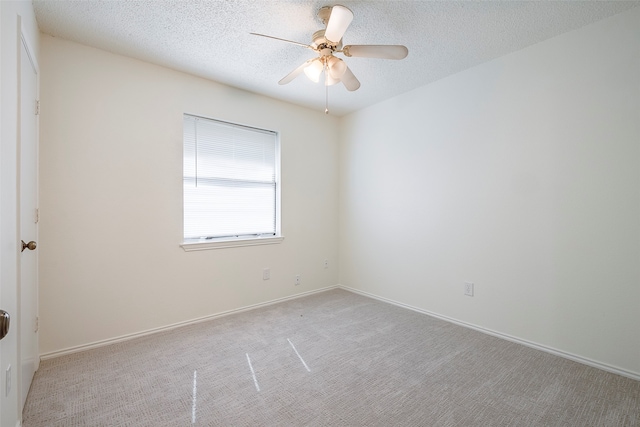 carpeted spare room with a textured ceiling and ceiling fan