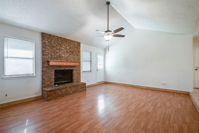 unfurnished living room with light wood-type flooring, a ceiling fan, a textured ceiling, and lofted ceiling