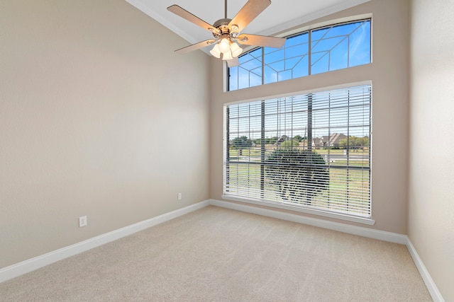 unfurnished room featuring a high ceiling, carpet flooring, and ceiling fan