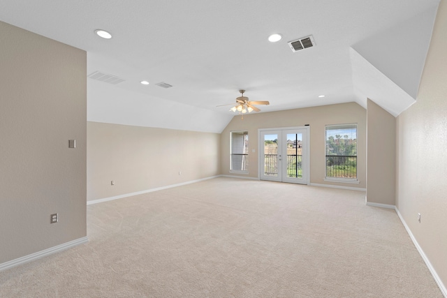 empty room featuring french doors, ceiling fan, light carpet, and lofted ceiling