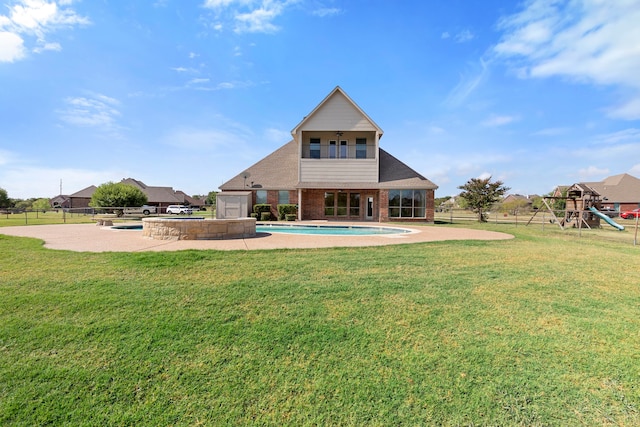 back of house with a patio, a playground, a lawn, and a swimming pool with hot tub