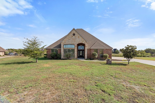 french provincial home with a front yard