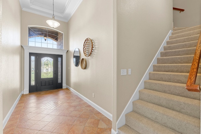 entrance foyer with a towering ceiling, light tile patterned floors, and crown molding