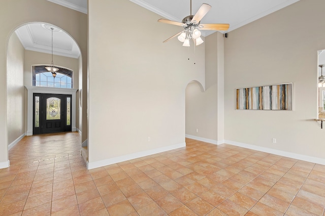 foyer with light tile patterned flooring, a towering ceiling, ceiling fan, and crown molding