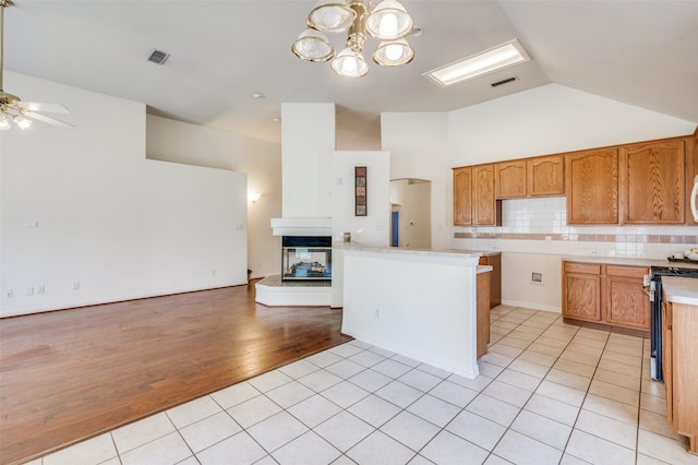 kitchen with light tile patterned floors, visible vents, open floor plan, and decorative backsplash