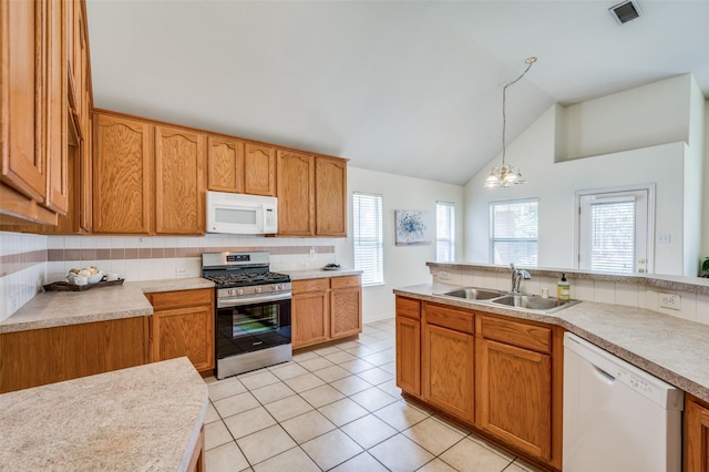 kitchen with a sink, visible vents, white appliances, and light countertops