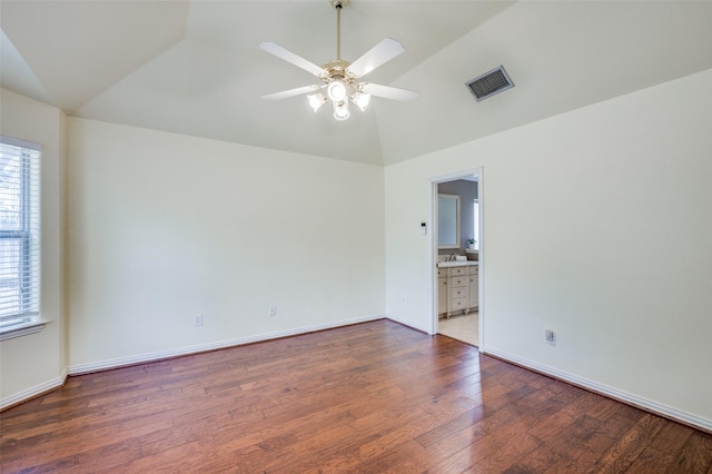 spare room featuring visible vents, baseboards, ceiling fan, vaulted ceiling, and wood finished floors