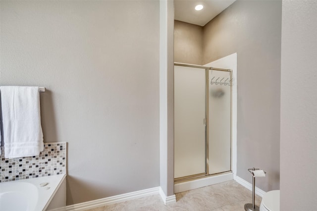 full bath featuring tile patterned floors, baseboards, toilet, a stall shower, and a bath