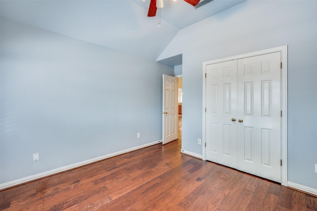 unfurnished bedroom with dark wood-type flooring, baseboards, visible vents, and lofted ceiling