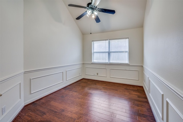 spare room with ceiling fan, lofted ceiling, dark wood-style flooring, and wainscoting