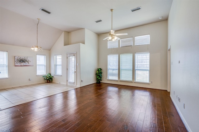 empty room featuring wood finished floors, visible vents, and a healthy amount of sunlight