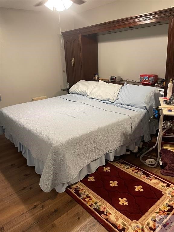 bedroom with ceiling fan and dark hardwood / wood-style floors