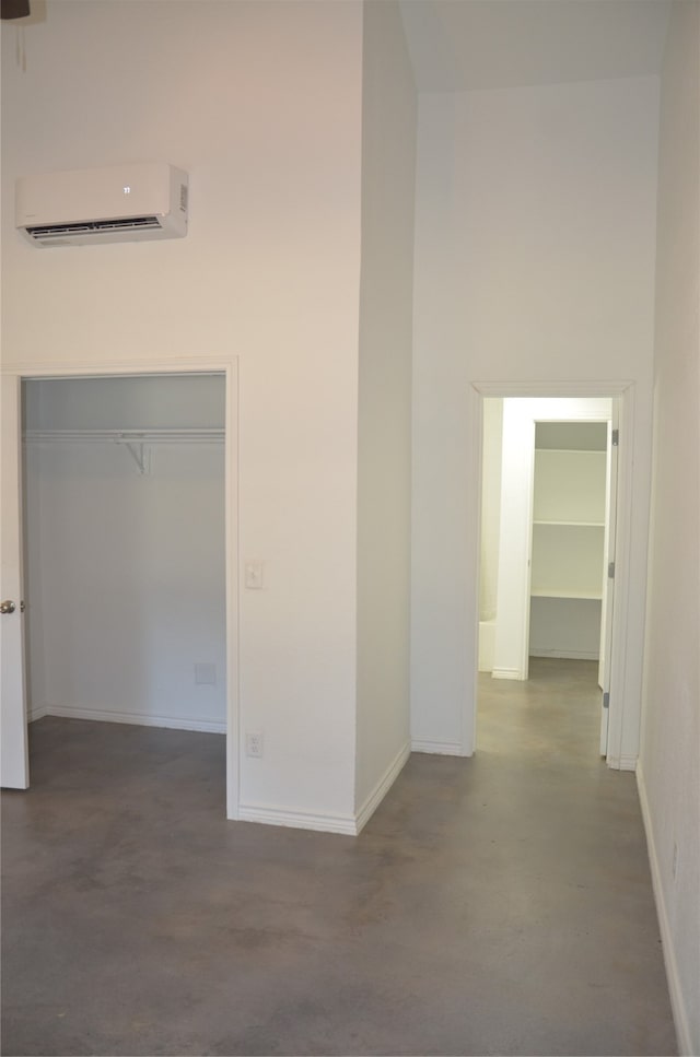 corridor featuring an AC wall unit and concrete floors