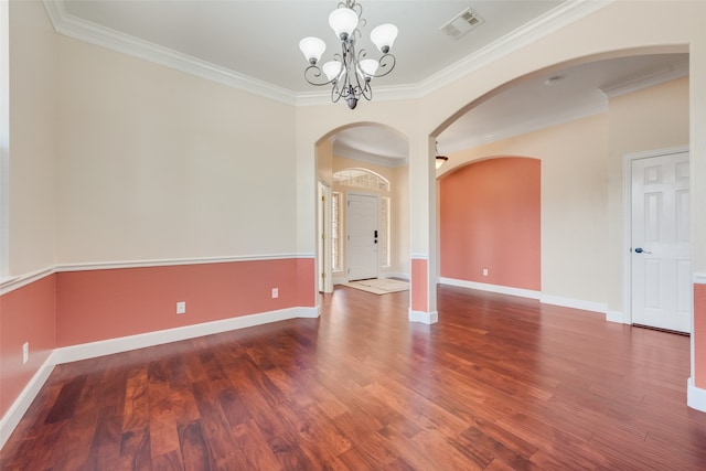 empty room featuring ornamental molding, a chandelier, and dark hardwood / wood-style floors