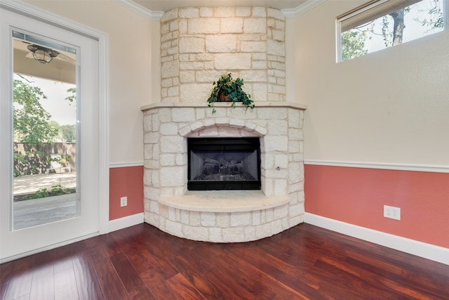 unfurnished living room with crown molding, dark wood-type flooring, and a fireplace