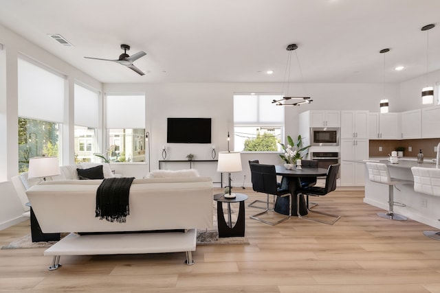 living room with ceiling fan and light hardwood / wood-style floors