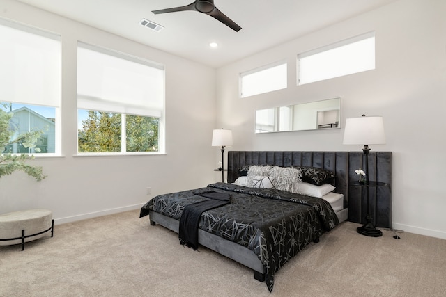 carpeted bedroom with ensuite bathroom and ceiling fan