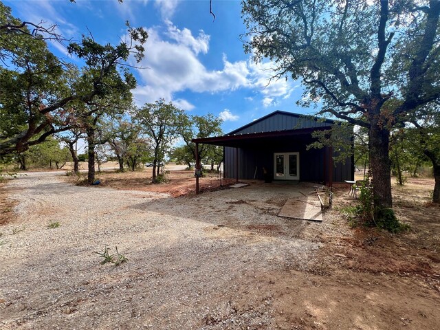 exterior space with dirt driveway and french doors