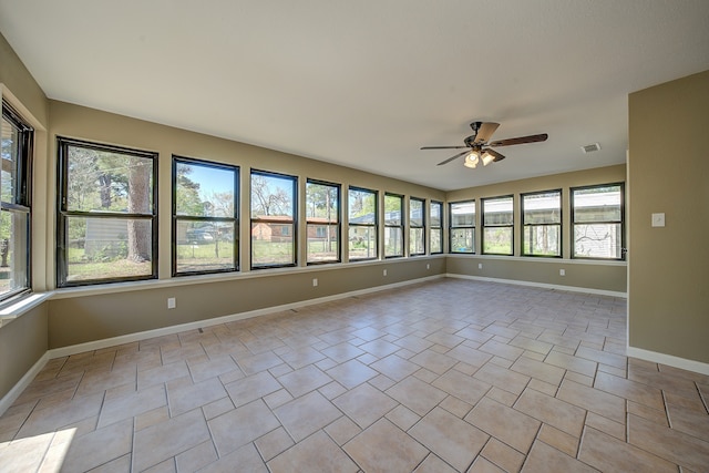 tiled empty room with plenty of natural light and ceiling fan