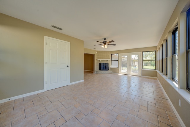 interior space featuring ceiling fan, french doors, and a fireplace