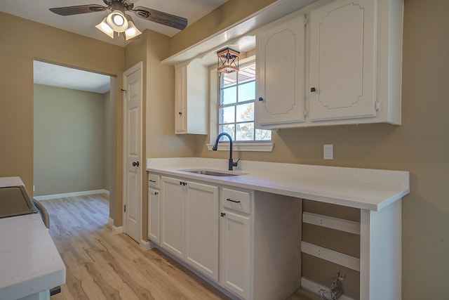 kitchen featuring ceiling fan, sink, white cabinets, and light hardwood / wood-style floors