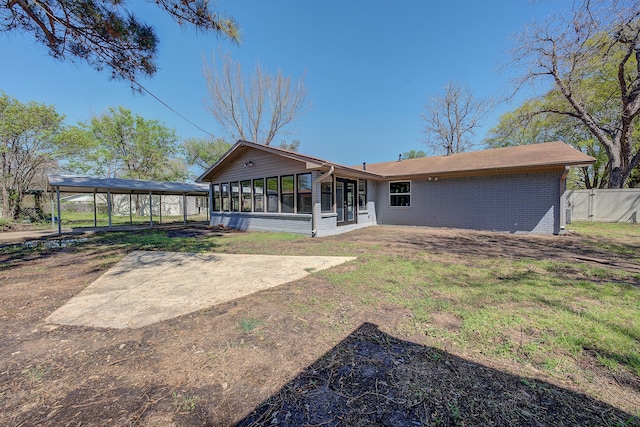 back of property with a sunroom and a yard