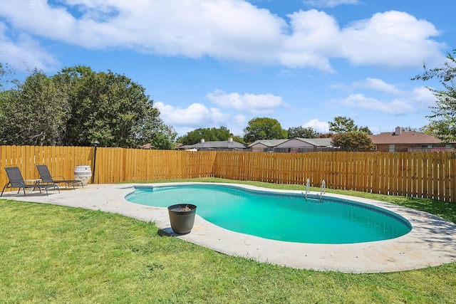 view of swimming pool featuring a yard and a patio area