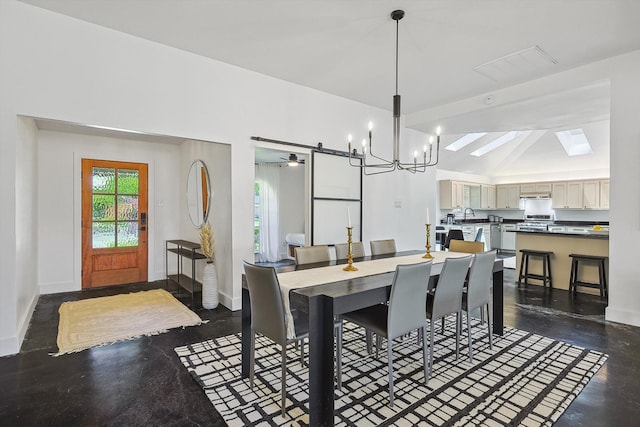 dining room with a barn door, an inviting chandelier, and lofted ceiling with skylight