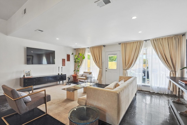 living room featuring a wealth of natural light and concrete floors