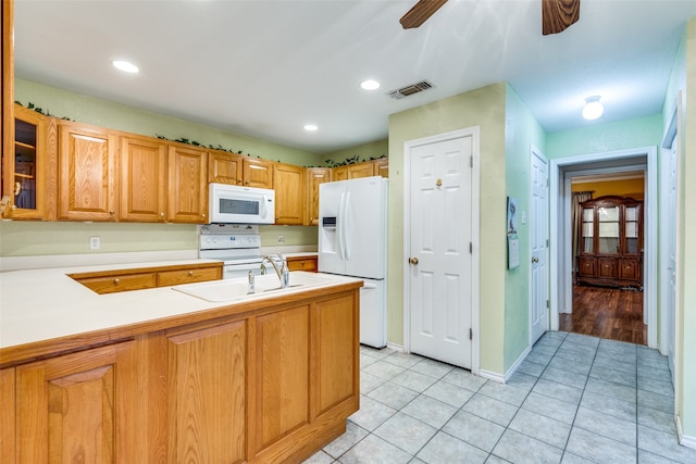 kitchen with white appliances, light hardwood / wood-style flooring, kitchen peninsula, sink, and ceiling fan