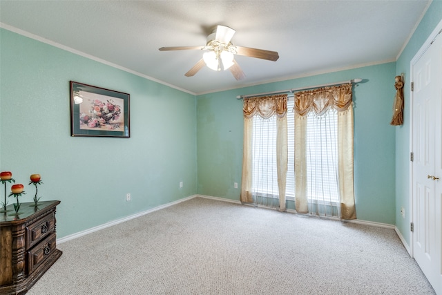 spare room with crown molding, carpet flooring, and ceiling fan