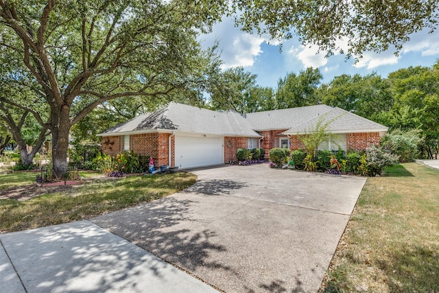 single story home with a front yard, brick siding, concrete driveway, and an attached garage