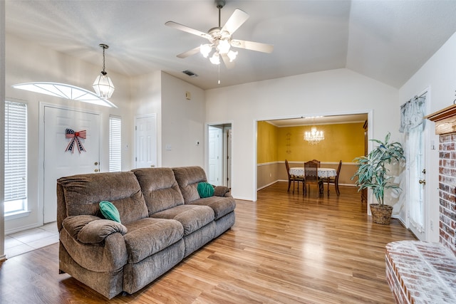 living room with light wood-type flooring, vaulted ceiling, and ceiling fan