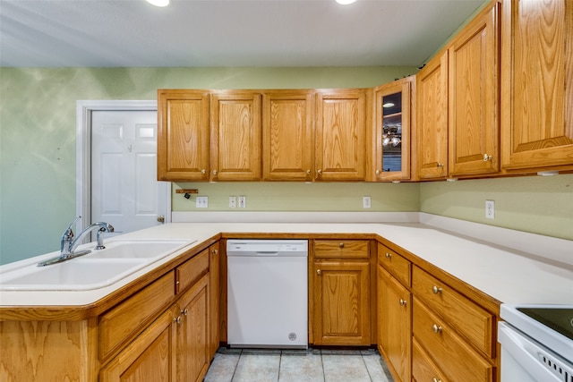 kitchen featuring dishwasher, kitchen peninsula, sink, and light tile patterned floors