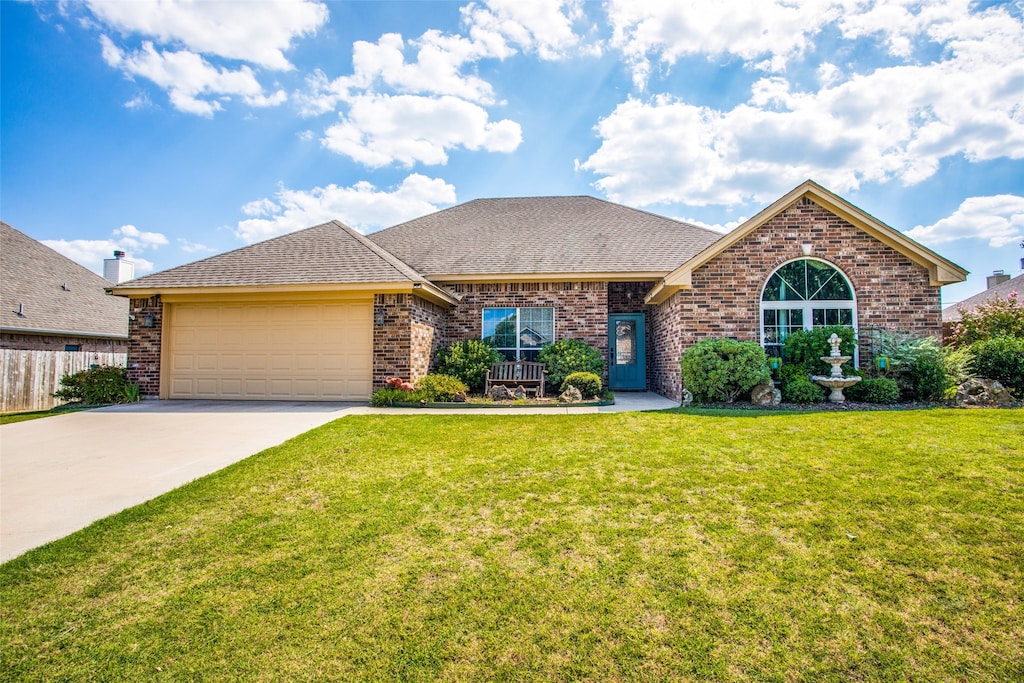 ranch-style house featuring a garage and a front yard