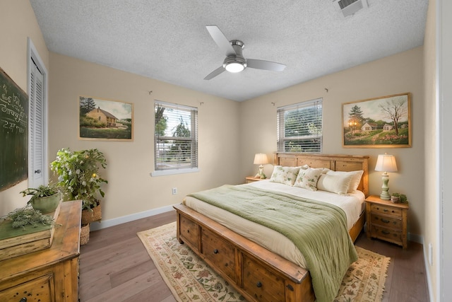 bedroom featuring baseboards, multiple windows, visible vents, and light wood-style floors