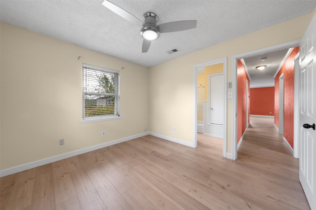 empty room featuring light hardwood / wood-style flooring, a textured ceiling, and ceiling fan