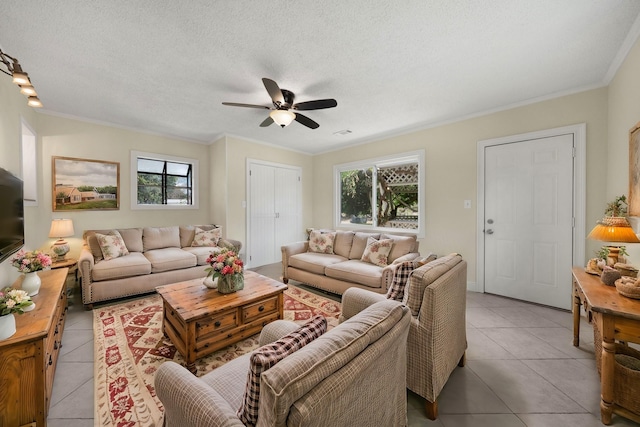 living area with light tile patterned floors, ornamental molding, and a textured ceiling