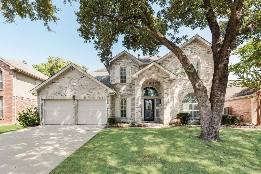 view of front of property featuring a garage and a front lawn