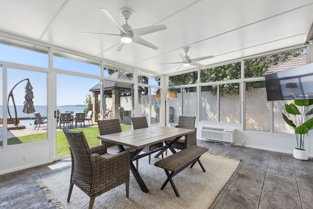 sunroom featuring ceiling fan, a wall mounted air conditioner, and a water view