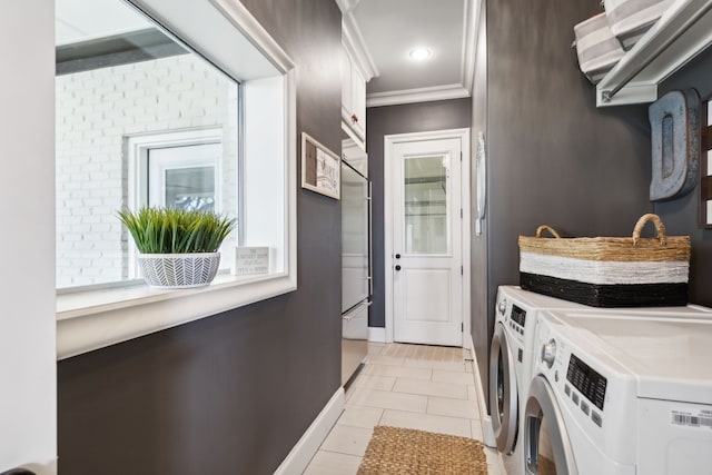 laundry area with ornamental molding, washer and clothes dryer, light tile patterned floors, and cabinets