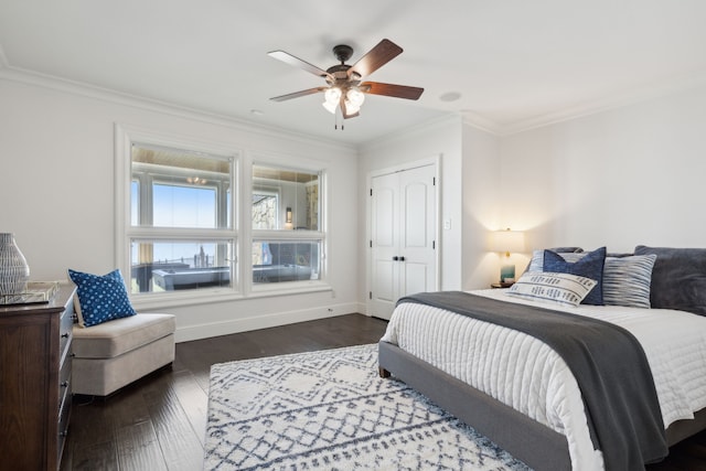 bedroom featuring ceiling fan, ornamental molding, a closet, and dark wood-type flooring