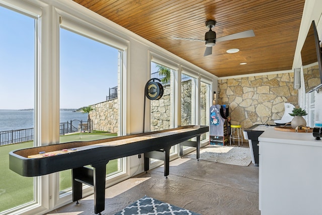 game room with a water view, wood ceiling, and ceiling fan