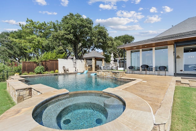 view of swimming pool featuring an in ground hot tub and a patio area