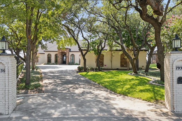 view of front of house featuring concrete driveway, a front lawn, and brick siding